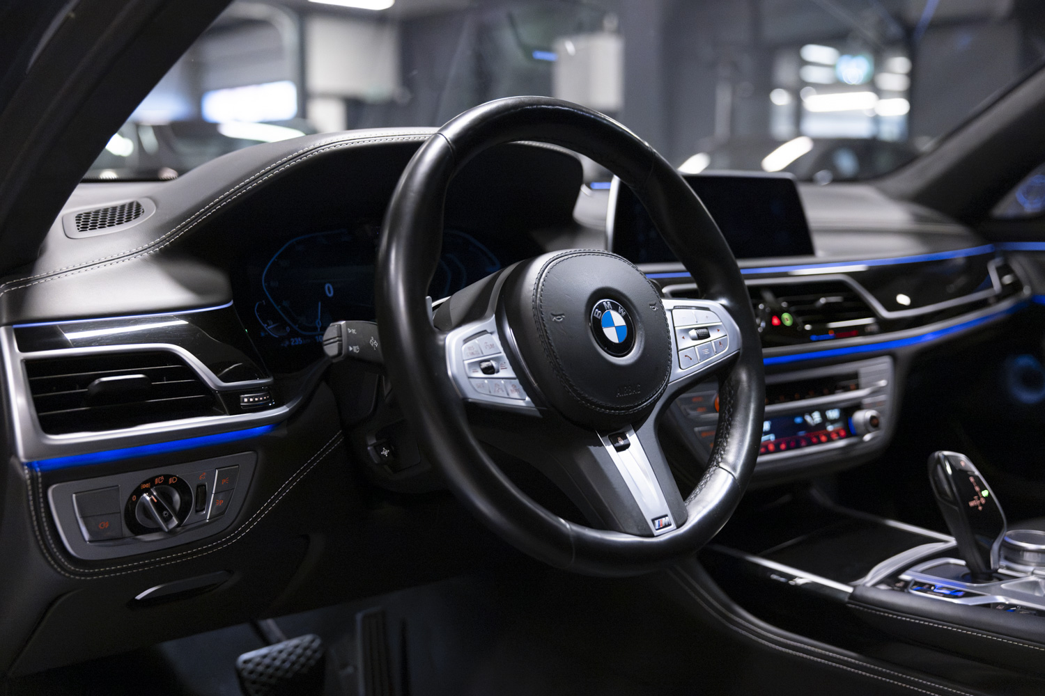 Interieur van een BMW met stuur en sfeerverlichting