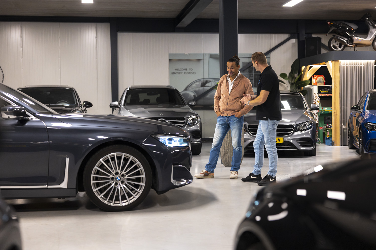 Klant en verkoper in gesprek naast een BMW in de showroom